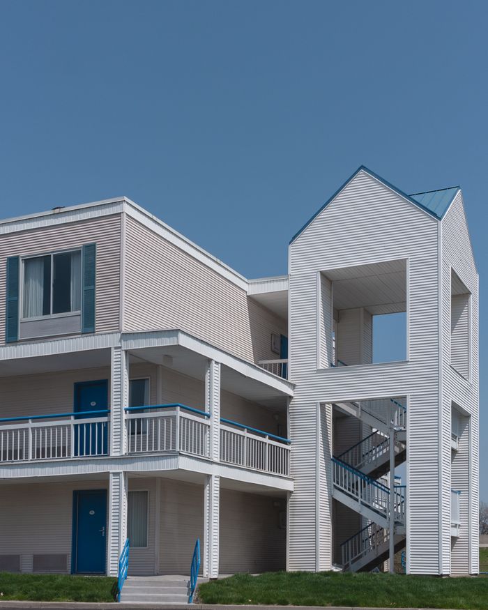 Contemporary apartment building with blue accents against a clear sky, showcasing modern architecture.